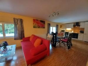a living room with a red couch and a table at Ferienhaus du Bourguignon, Lorraine in Saint-Quirin