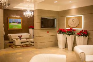 a lobby with a waiting room with red flowers at Hotel Opera in Tirana