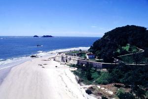 a view of a beach with a house and the ocean at Kit do Madruga in Ilha do Mel