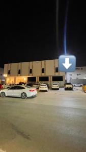 two cars parked in a parking lot in front of a building at استديو فندقي واسع بالورود in Al Kharj