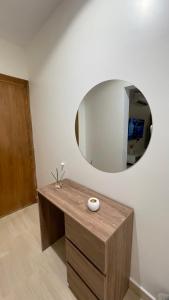 a mirror on the wall above a wooden dresser at استديو فندقي واسع بالورود in Al Kharj