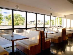 a restaurant with tables and chairs and large windows at Flat Presidencial Vivence Hotel in Palmas