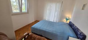 ein Schlafzimmer mit einem blauen Bett und einem Fenster in der Unterkunft Apartments by the sea Mirca, Brac - 5655 in Mirce