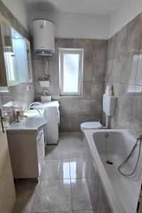 ein Badezimmer mit einer Badewanne, 2 Waschbecken und einer Badewanne in der Unterkunft Apartments by the sea Mirca, Brac - 5655 in Mirce