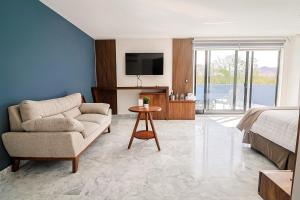 a bedroom with a couch and a bed and a television at Hotel Guiant in Santa María del Río