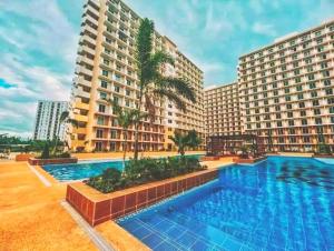 a swimming pool in front of two large buildings at saekyung marigondon 1 in Lapu Lapu City