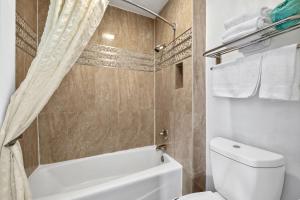 a bathroom with a toilet and a tub and a shower at Executive Inn in Milpitas +12 photos