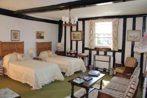 um quarto com 2 camas, uma cadeira e uma mesa em Haughley House em Stowmarket