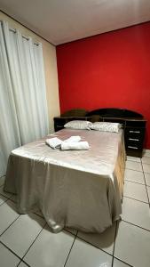 ein Schlafzimmer mit einem Bett mit zwei Handtüchern darauf in der Unterkunft Suíte privativa com cozinha completa, ar e Wi-Fi in Palmas