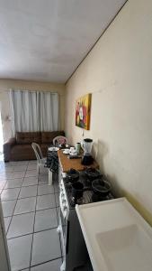 eine Küche mit Herd, Tisch und Couch in der Unterkunft Suíte privativa com cozinha completa, ar e Wi-Fi in Palmas