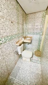 ein gefliestes Badezimmer mit Toilette und Waschbecken in der Unterkunft Suíte privativa com cozinha completa, ar e Wi-Fi in Palmas
