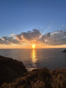 a sunset over the ocean with the sun in the sky at IZU Elysian View in Koura