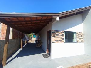 eine Veranda eines Gebäudes mit einem Holzdach in der Unterkunft Casa Porto Maringá in Marilena