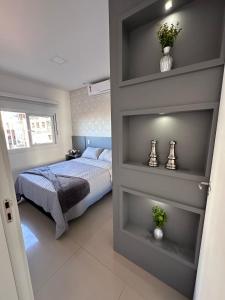 1 dormitorio con 1 cama y estanterías en una habitación en Janela para o Mar, en Capão da Canoa