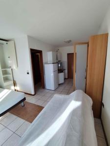a room with a bed and a kitchen with a refrigerator at Apartments in Eraclea Mare 53760 in Eraclea Mare +13 photos