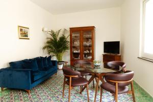 a living room with a blue couch and a table at Casa Lauritano in Atrani