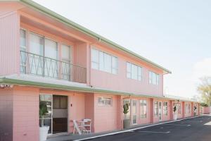 a pink building with a balcony on a street at The Mayfair in Hastings