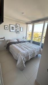 a bedroom with a bed and a large window at A pasos del metro Steps away from the subway in Santiago
