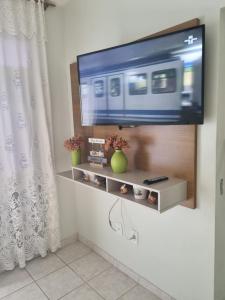 a flat screen tv on a wall in a living room at Ed Ravena Com vista mar e elevador in Guarapari +18 photos