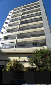 a tall building with trees in front of it at Ed Ravena Com vista mar e elevador in Guarapari