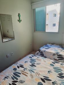 a bedroom with a bed and a mirror and a window at Ed Ravena Com vista mar e elevador in Guarapari