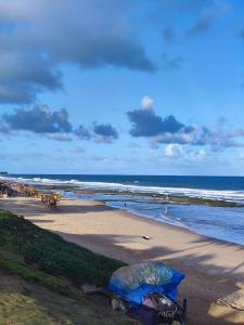 a beach with people on the sand and the ocean at Village Beira mar in Lauro de Freitas +7 photos