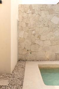 bagno con parete in pietra e piscina di Villa Victoria Xico a Xico