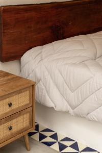 a bed with a wooden headboard next to a night stand at Villa Victoria Xico in Xico +24 photos