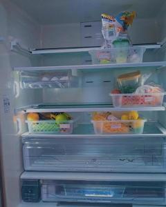 an open refrigerator filled with lots of food at Le house hostel in São Paulo
