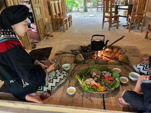 a young child sitting around a table with a fire at Dao House in Ðà Bắc