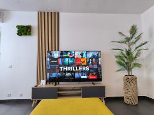 a living room with a flat screen tv on a stand at City Lodge Papeete in Papeete