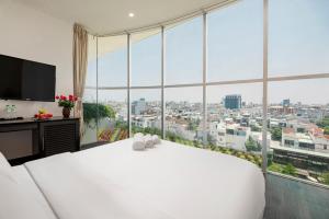 岘港Hold Amanda Boutique Hotel的卧室里有一张白色的大床和一扇大窗户