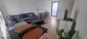 a living room with a couch and a table at Le Repos Urbain-Grand T3 Cosy à 10 min de Paris & CDG in La Courneuve