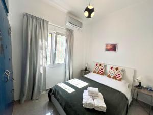 a bedroom with a bed with two towels on it at sky inn with wonderful Acropolis view in Neos kosmos in Athens