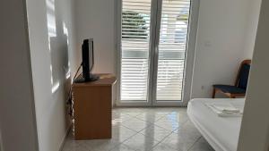 a room with a bed and a television on a dresser at Apartment Palma - Novalja in Novalja