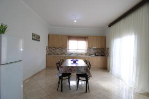 a kitchen with a table with chairs and a refrigerator at Vila Eni - Mario in Ksamil