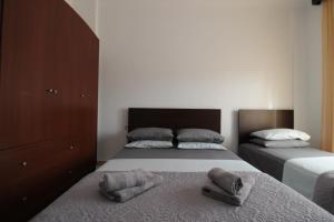 a bedroom with two beds and a dresser at Vila Eni - Mario in Ksamil