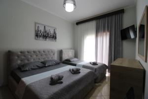a bedroom with two beds and a window at Vila Eni - Mario in Ksamil
