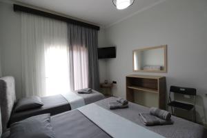 a hotel room with two beds and a mirror at Vila Eni - Mario in Ksamil