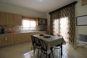 a kitchen with a table with chairs and a window at Vila Eni - Mario in Ksamil