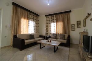a living room with a couch and a coffee table at Vila Eni - Mario in Ksamil