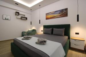 a bedroom with a large bed and a chair at Vila Eni - Mario in Ksamil