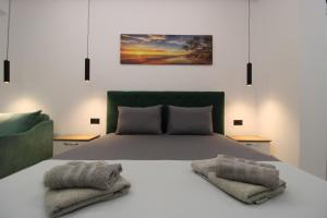 a bedroom with a bed with two towels on it at Vila Eni - Mario in Ksamil