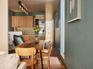 a kitchen and dining room with a wooden table and chairs at Stylish Stay with Sauna in Antoing