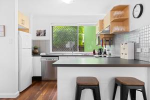 a kitchen with a counter and two stools at Spacious 3-Bed House in Leafy Paddington in Brisbane