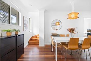 a dining room with a white table and chairs at Spacious 3-Bed House in Leafy Paddington in Brisbane