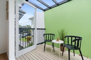 a balcony with two chairs and a table at Spacious 3-Bed House in Leafy Paddington in Brisbane +17 photos