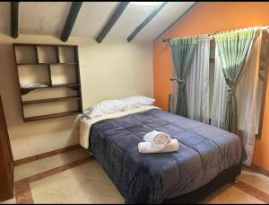 a bedroom with a bed with towels on it at Villa Cemandy Apartment in Villa de Leyva