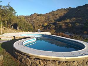 een zwembad met een stenen muur eromheen bij Lagriega in Cuesta Blanca