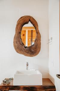 a bathroom with a sink and a mirror at Chalés Bosque das Oliveiras in Urubici +94 photos